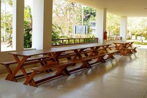 long wooden table placed under the building for sitting, relaxing, working. Soft and selective focus. photo