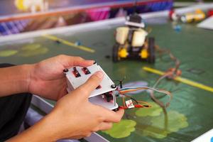 Asian high school students practice moving robots on the playing field To perform missions according to the rules of the robot competition. Soft and selective focus. photo