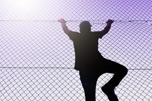 Bilbao, Vizcaya, Spain, 2023 - man climbing the metal fence photo
