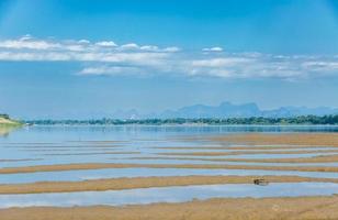 Scenery view of cloudy blue sky with the Mekong river as a background and sandy beach as a foreground. photo