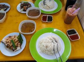 Two servings of Malacca's specialty hainan rice, a portion of nasi lemak with fresh gravy and a delectable grilled chicken breast photo