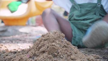 detailopname van zwart mensen jongen spelen zand in speelplaats in park video