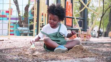 African American boy playing sand in playground video