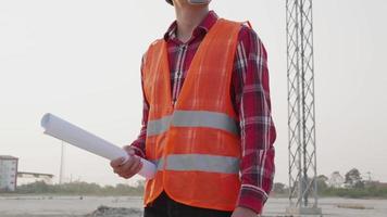retrato do ásia masculino engenheiro em pé em campo com eletricidade torres. trabalho em equipe, Liderança video