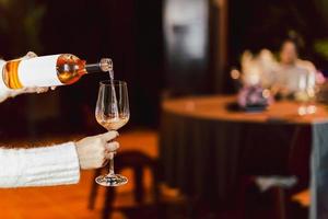 Woman pouring rose wine from bottle into glass lifestyle concept. photo