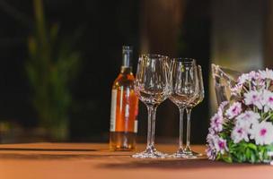 Empty wine glasses and bottle of wine on table. photo