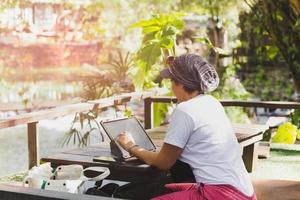 Woman working on laptop in cafe outdoor travel concept. photo