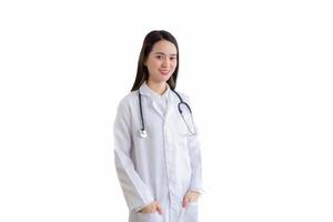Professional Asian woman doctor wears medical coat while standing confidently smiling and hand in shirt pocket isolated on white background in health protection concept. photo