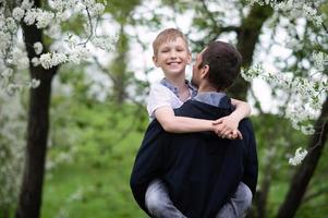 el chico en de papá brazos mira a el cámara y sonrisas foto