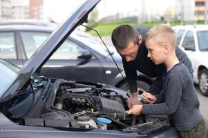 Dad shows his little happy son how the car works photo