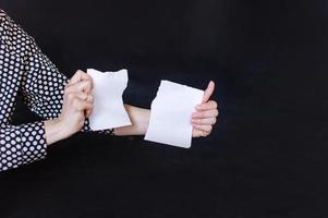 Hands holding a sheet of paper torn into two parts photo