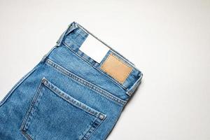 A pair of denim trousers with an empty leather label . photo