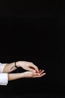 Women's hands with a bracelet on a black background photo