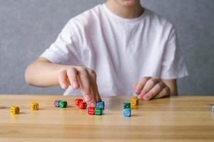 A boy is playing with colorful playing cubes photo