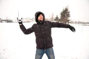 A man is playing snowballs and smiling photo