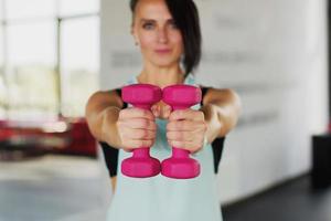 un mujer lo hace Deportes ejercicios con pesas en el gimnasio foto