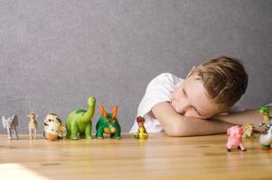 The child plays with figurines of animals stand on the table toys photo