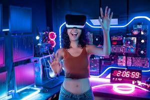 un joven asiático mujer utilizando virtual realidad , vr caja a jugar en línea juego o reloj película foto