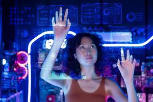 un asiático mujer es conmovedor interfaz en virtual realidad pantalla , tecnología futurista concepto . foto