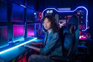 an asian woman programmer is working in her computer room , futuristic technology concept photo