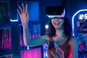 un joven asiático mujer utilizando virtual realidad , vr caja a jugar en línea juego o reloj película foto