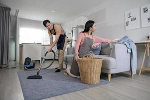 Happy young Asian couple cleaning home together, healthy lifestyle concept photo