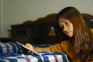 Asian women scramble from work sit beside the bed photo