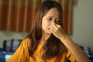 asiático mujer teniendo que produce picor nariz foto