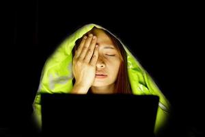 Asian women suffer from eyestrain from looking at computers in low light. watch movies online photo