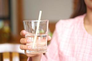 a glass of water in a woman's hand photo