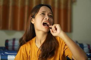 asiático mujer teniendo que produce picor labios foto