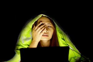 Asian women suffer from eyestrain from looking at computers in low light. watch movies online photo