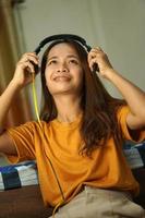 Asian woman listening to music in her room happily photo