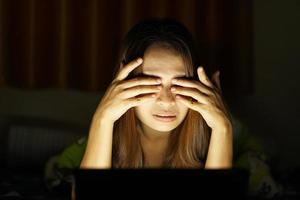 Asian women suffer from eyestrain from looking at computers in low light. watch movies online photo