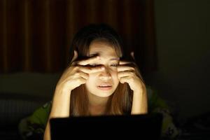 Asian women suffer from eyestrain from looking at computers in low light. watch movies online photo