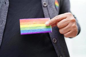 mujer asiática con bandera del arco iris, derechos de símbolos lgbt e igualdad de género, mes del orgullo lgbt en junio. foto