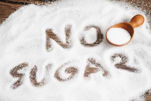 sin azúcar, azúcar granulada dulce con texto, prevención de diabetes, dieta y pérdida de peso para una buena salud. foto