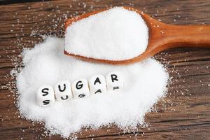 azúcar, azúcar granulada dulce con texto, prevención de diabetes, dieta y pérdida de peso para una buena salud. foto