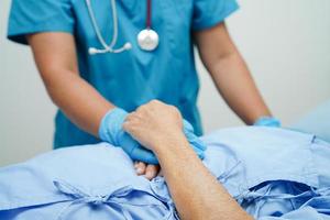 Doctor holding hands Asian elderly woman patient, help and care in hospital. photo