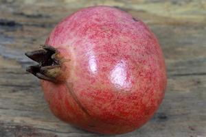Pomegranate isolated on the wooden background photo
