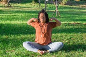 Woman is doing yoga asana outside in a park. Concept of balancing and healthy lifestyle. photo