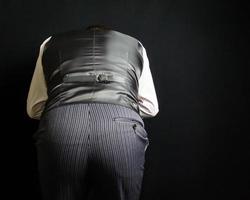 Portrait of Butler or Waiter in Vest Bowing in Polite Courtesay. Concept of Service Industry and Professional Hospitality. photo