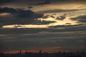 oscuro azul nube con blanco ligero puesta de sol cielo antecedentes y ciudad ligero medianoche noche hora foto