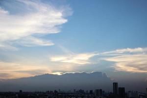 oscuro azul nube con blanco ligero puesta de sol cielo antecedentes y ciudad ligero medianoche noche hora foto