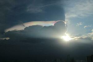 dark blue cloud with white light sky and sun ray with rainbow color reflection background photo