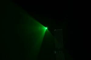 green beam laser beam on dark background photo