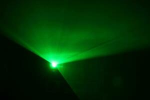 green beam laser beam on dark background photo