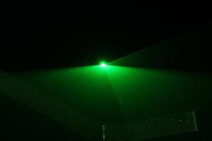 green beam laser beam on dark background photo