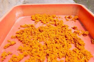 ground turmeric that is dried in the sun on a tray photo
