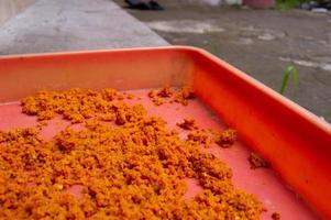 ground turmeric that is dried in the sun on a tray photo